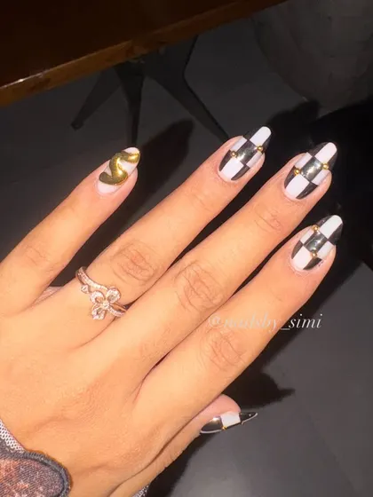 Trust me, these nails are an addiction. This classy and bold set features a black and white checkerboard pattern with gold chrome accents and a Chanel logo nail.