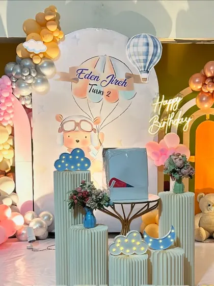 A charming hot air balloon and teddy bear theme in pastel and retro colors. This setup includes multiple arches, balloon clouds, and light-up elements for a dreamy second birthday.