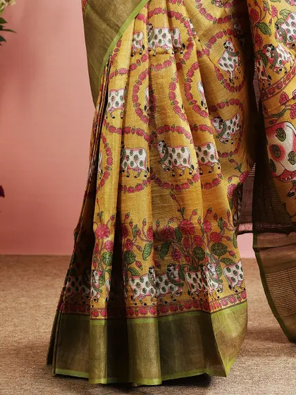 A detailed shot of the lower part of the saree, showing the intricate print and the green border.