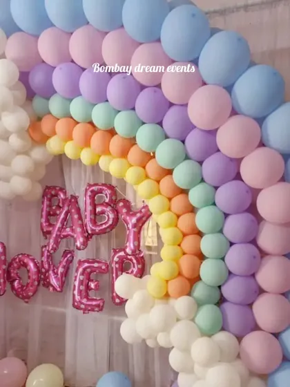 A clear shot of the pastel rainbow balloon arch, perfect for a joyful baby shower. The arrangement of colors from blue to pink to yellow creates a beautiful and eye-catching focal point.