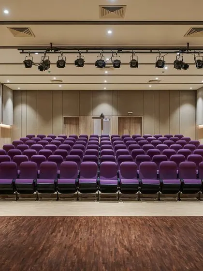 The 100-seater auditorium at the KIPCER building in Bengaluru. We designed this interior space with a warm, neutral palette of beige and brown to create a welcoming and focused environment for learning and knowledge sharing in palliative care.