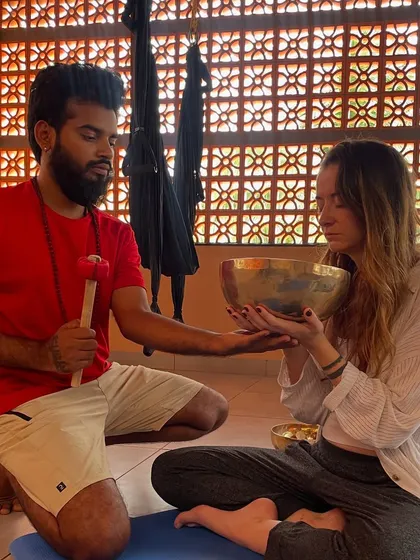Teaching a participant how to hold and play a singing bowl.