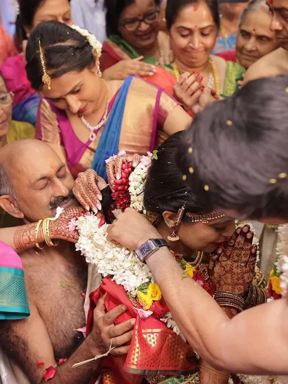 A beautiful moment between the bride and her father during the wedding ceremony, with her intricate mehendi on display.