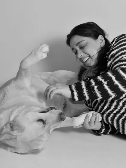 A happy dog getting a belly rub is a picture of pure bliss. This black and white image captures a moment of trust and affection between this Labrador and his mom.