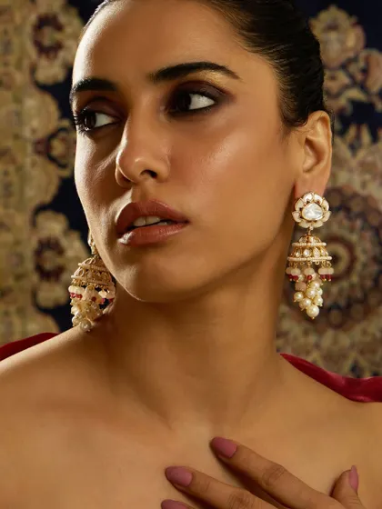 A beautiful pair of jhumkas with a floral polki stud and a cascade of pearls and pastel-colored beads, as worn by Sargun Mehta.