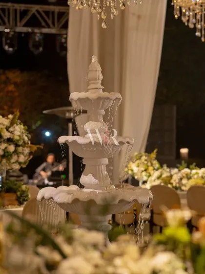 A close-up of the serene marble fountain, which served as a whispering centerpiece for the reception. Surrounded by florals, it added a calming and classic element to the luxurious design.