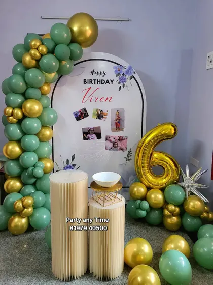 A sophisticated 6th birthday setup with sage green and gold balloons, a custom photo backdrop, and a number '6' balloon bouquet.