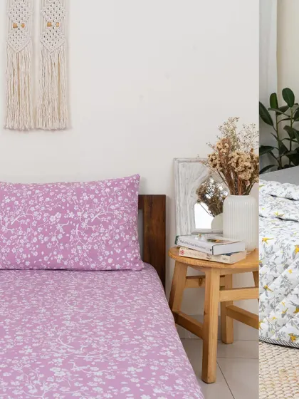 A split view showing two of our popular bedding designs. On the left, the delicate 'Cherry Blossom' print in lilac, and on the right, the cheerful 'Winged Skies' quilt. Both are perfect for adding a touch of nature to your bedroom.