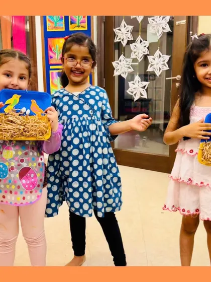 Three happy students showing off their bird's nest craft. Art plus laughter equals childhood magic, and these smiles prove it.