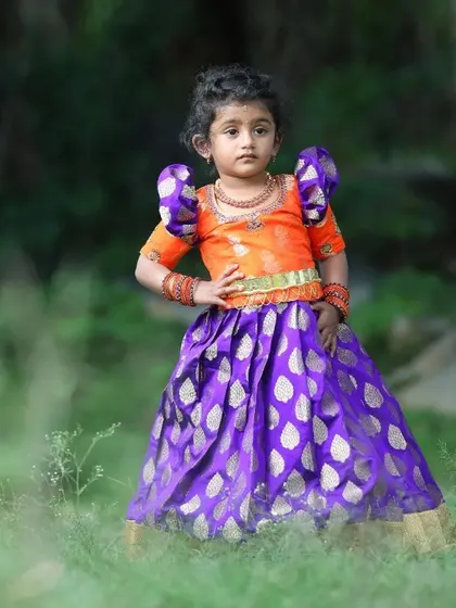 Here is the elder sister showing off her outfit with a confident pose. The rich colors and classic silhouette make this a perfect choice for any festive occasion or family celebration.