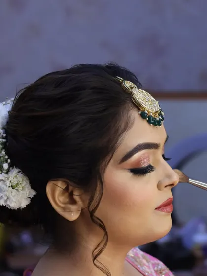 A side view of the eye makeup application. Here, I'm adding a final touch of powder to set the under-eye area, ensuring a crease-free finish all day.