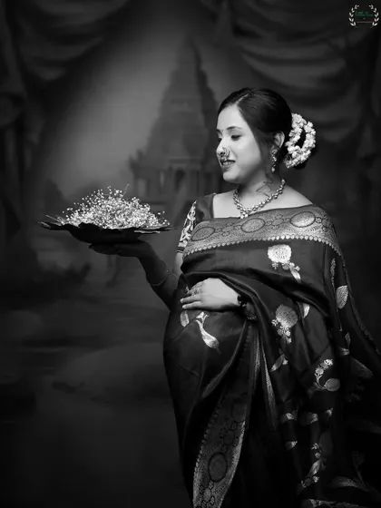 A stunning black and white portrait that feels like a vintage painting. The traditional attire and props create a timeless and artistic image.