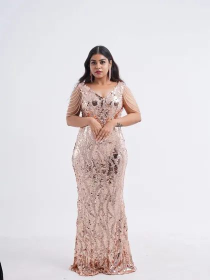 A full-length shot of a model in a stunning rose gold sequin gown, perfect for turning heads at any event.