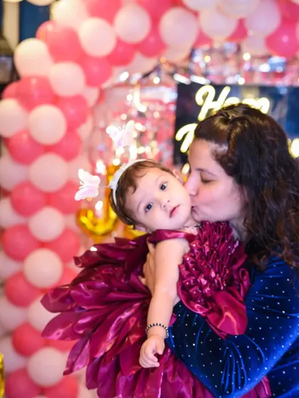 A mother's tender kiss for her daughter on her birthday. A beautiful, emotional shot.