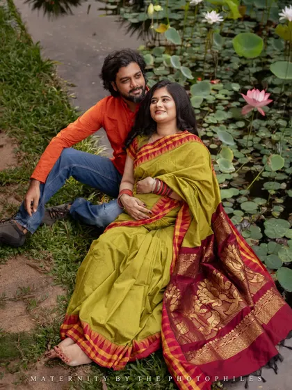 A serene moment captured by a lotus pond. The natural setting provides a peaceful and beautiful backdrop for this couple's maternity session, reflecting the tranquility and beauty of this special time.