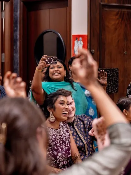 A candid moment of joy and celebration, with guests dancing and capturing memories on their phones.