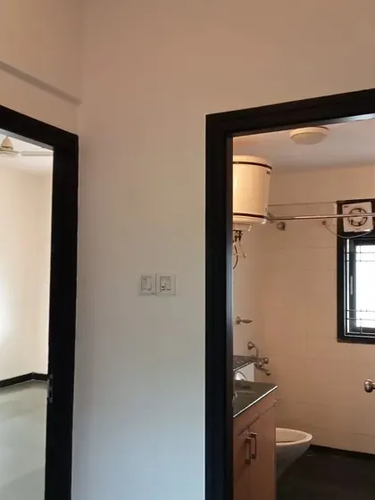 A hallway with crisp off-white walls and contrasting dark-painted door frames. This detail adds definition and a modern touch to the interior space.