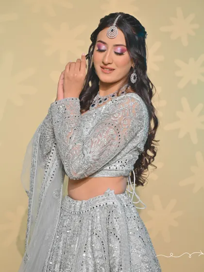 A dreamy look in a silver-grey lehenga with a pop of pink on the eyes. This is a great example of our students' ability to create modern and fresh looks.