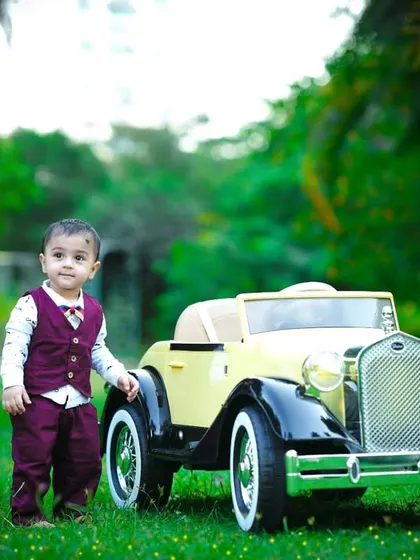 Standing next to his cool ride, this one-year-old is ready for his next adventure.