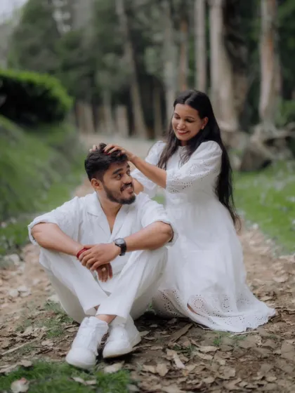 A sweet, candid moment on a forest trail, where the bride-to-be gently caresses her partner's hair.