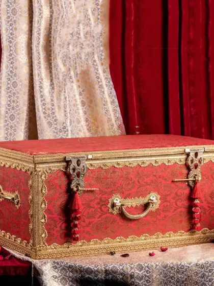 A magnificent red and gold brocade 'sanduk' or trunk, perfect for presenting a bride's trousseau in a grand and traditional style.