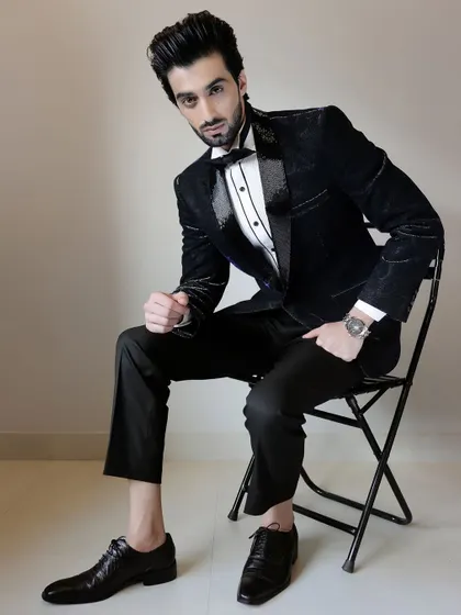 This black-on-black patterned tuxedo is the epitome of subtle sophistication. The jacquard fabric features a paisley design that adds texture and depth, while the sequined lapels provide a touch of evening glamour.