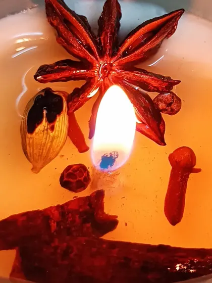 This lit candle demonstrates the excellent hot throw of my spice-infused fragrances. You can see the whole star anise, cinnamon, and cloves that release a warm, festive aroma as the candle burns.
