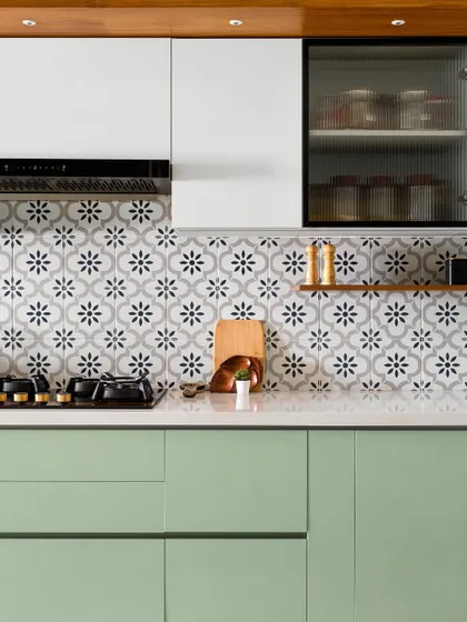 We call this the 'Garden of Eden' kitchen for its fresh green cabinetry, patterned floral tiles, and warm veneer accents. The combination of colors and textures creates a vibrant and refreshing culinary space.