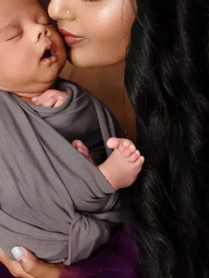 A close-up shot focusing on the mother's gentle kiss and the newborn's delicate features. These are the details you will cherish forever.
