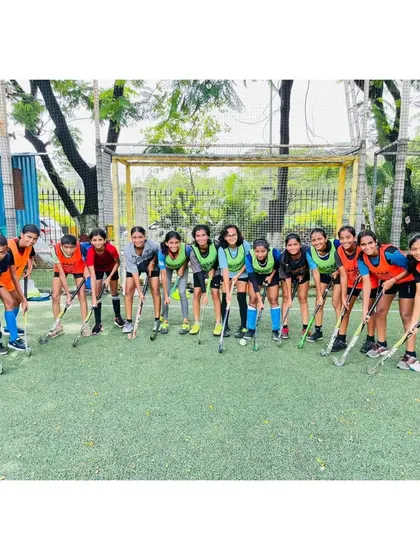 The girls' team poses together, ready to begin their drills. The mix of training bibs shows they are prepared for a competitive practice match.