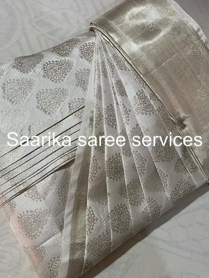 This white and silver silk saree is perfect for elegant evening events. It's been pleated and folded for easy use.