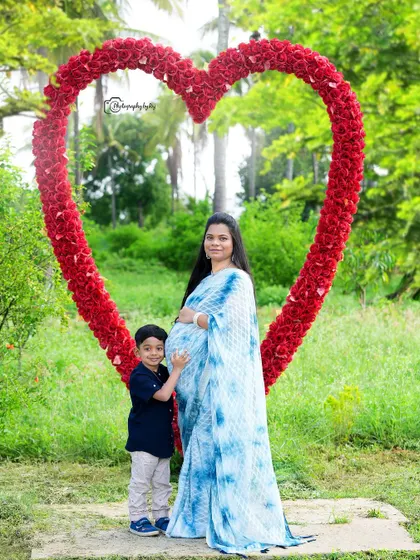 A mother and son pose in front of a large, heart-shaped floral prop in our garden. This setup adds a bold and romantic element to maternity photos, symbolizing the love that fills a growing family.