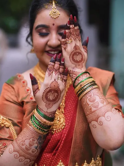 A happy client showing off her engagement mehendi. The design features a lovely lotus motif, symbolizing purity and beauty, which is perfect for such a special occasion.