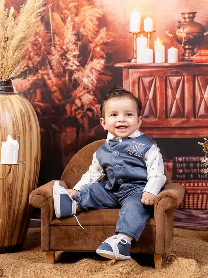 A dapper little gentleman in a rustic, candle-lit room. His charming smile and stylish outfit make for a beautiful and timeless portrait.