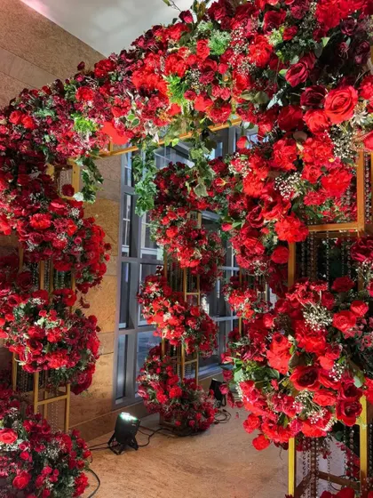 Step into a floral fantasy. This breathtaking entryway, overflowing with bold red blooms, creates an immersive and royal welcome for guests.