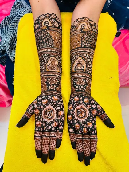 This engagement mehndi features beautiful peacock motifs and the couple's initials, 'S' and 'B', inside floral mandalas. The fingertips are kept dark for a striking contrast.