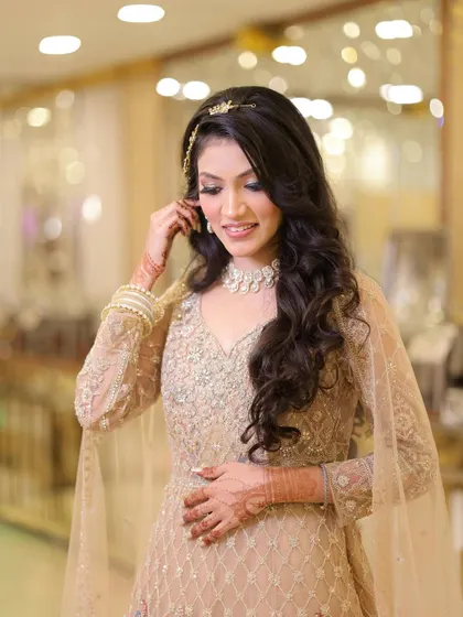 A candid, downward glance from the bride, showing off her long curls and the soft glam of her makeup.