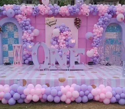 We love creating large-scale, impactful decorations for big celebrations. This first birthday stage setup features a massive balloon wall in pastel pink and purple, with marquee letters and custom-designed backdrops, turning the venue into a fairytale setting.