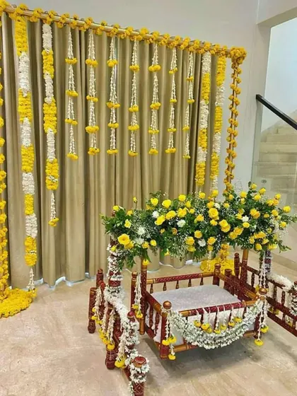 A classic and elegant jhula decoration for a home Janmashtami celebration. I used strings of fresh yellow marigolds and white rajnigandha flowers to create a beautiful backdrop for the cradle, which is also adorned with matching floral arrangements.