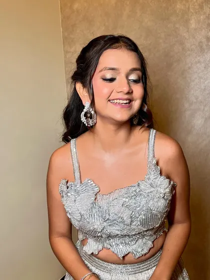 The soft waves and shimmery makeup create a glamorous and youthful look.