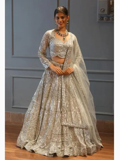 What you see is what you get with our outfits. This full shot shows the incredible sparkle and craftsmanship of our silver sequin lehenga, a perfect choice for a modern bride or guest.