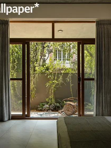 A bedroom view looking out into a private green courtyard. Every bedroom is designed to have its own personal connection to the landscape.