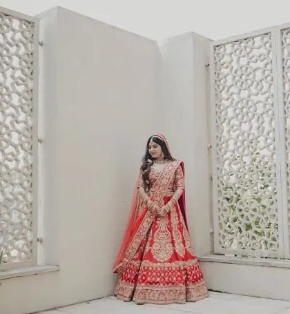 A stunning full-length portrait of the bride in her magnificent red wedding lehenga.