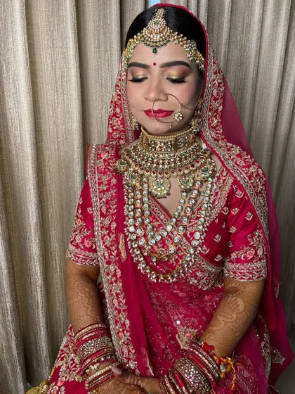 A close-up of the eye makeup, featuring a golden shimmer on the lid and a sharp wing, paired with a traditional red bindi.