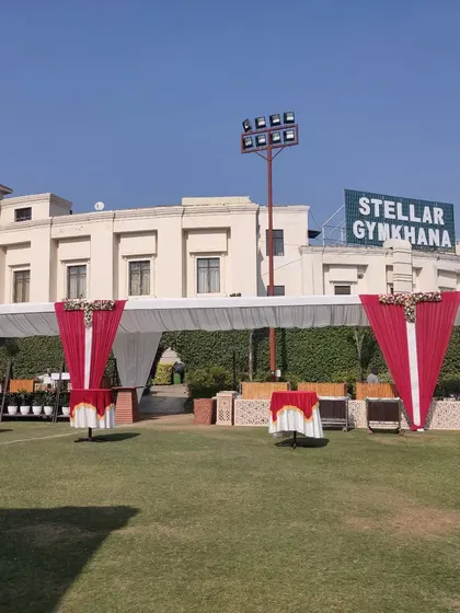 A wide shot of an event setup at Stellar Gymkhana, showing my capability to manage decor at large, well known venues in Greater Noida. The image displays the tent structure and entrance decor.
