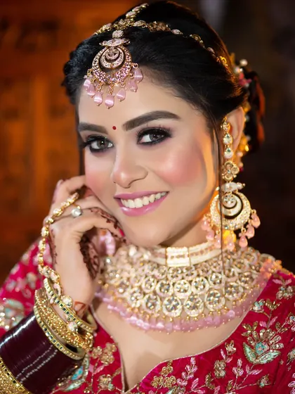 This bride is all smiles, and her makeup reflects her happy mood. A bright pink lip and shimmering eyes pair perfectly with her pink and gold jewelry.