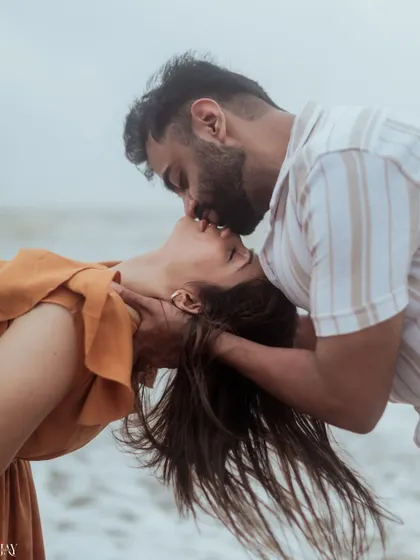 An intimate and passionate kiss, with the ocean as the only witness. This close-up captures the raw emotion of a beach pre-wedding shoot.
