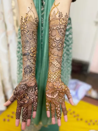 A full view of the elbow-length bridal henna on both arms, showing the intricate and symmetrical design.