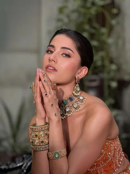A striking pose showing the dewy, flawless base that catches the light just right. The eyes are minimal but striking with earthy tones and a touch of highlight.
