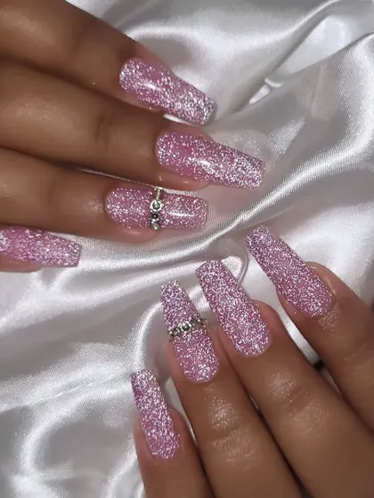A full view of the sparkling pink party nails. The added rhinestone rings on the accent nails give them an extra touch of luxury.